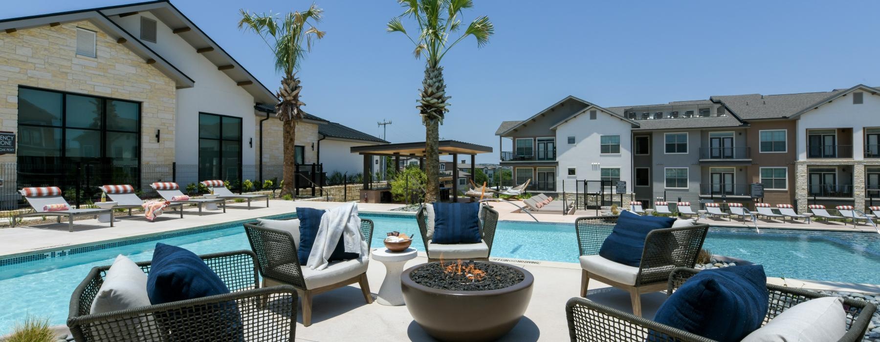 a pool with chairs and tables by it