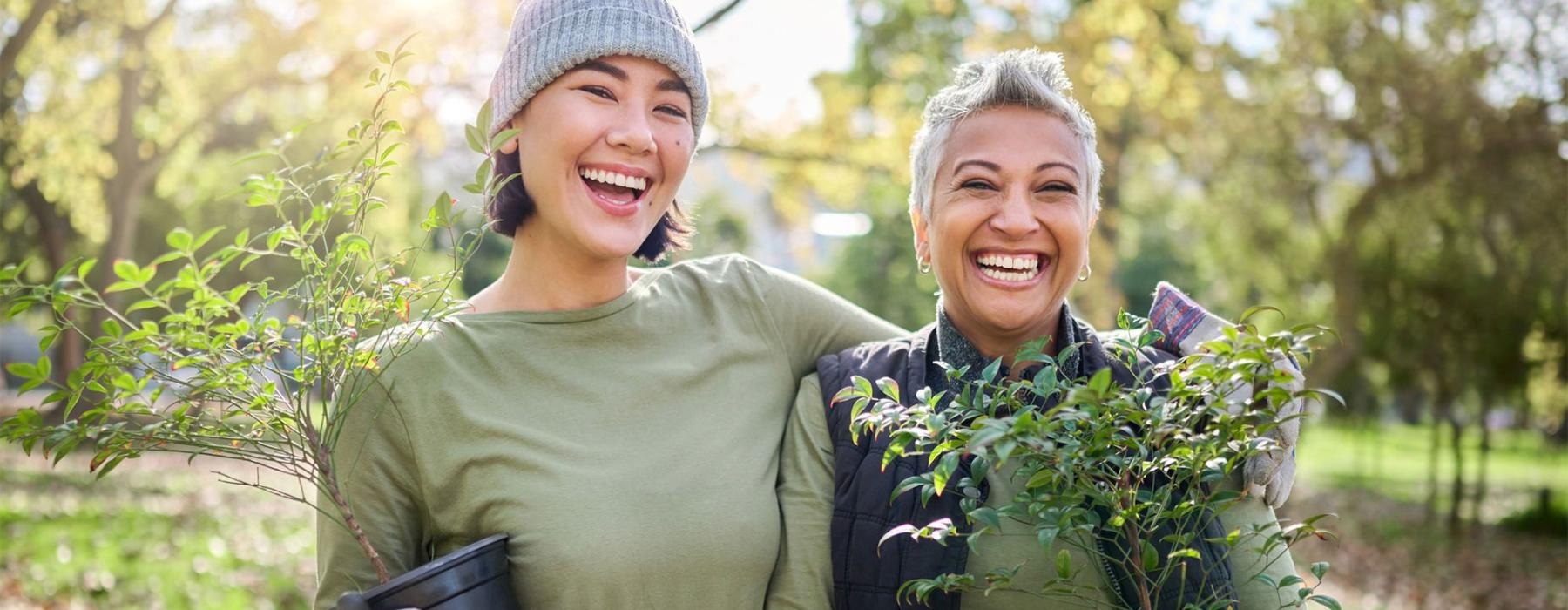 a couple of women holding plants